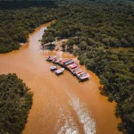 Aerial view of Amazon rainforest with deforested patches and cleared land visible through mist