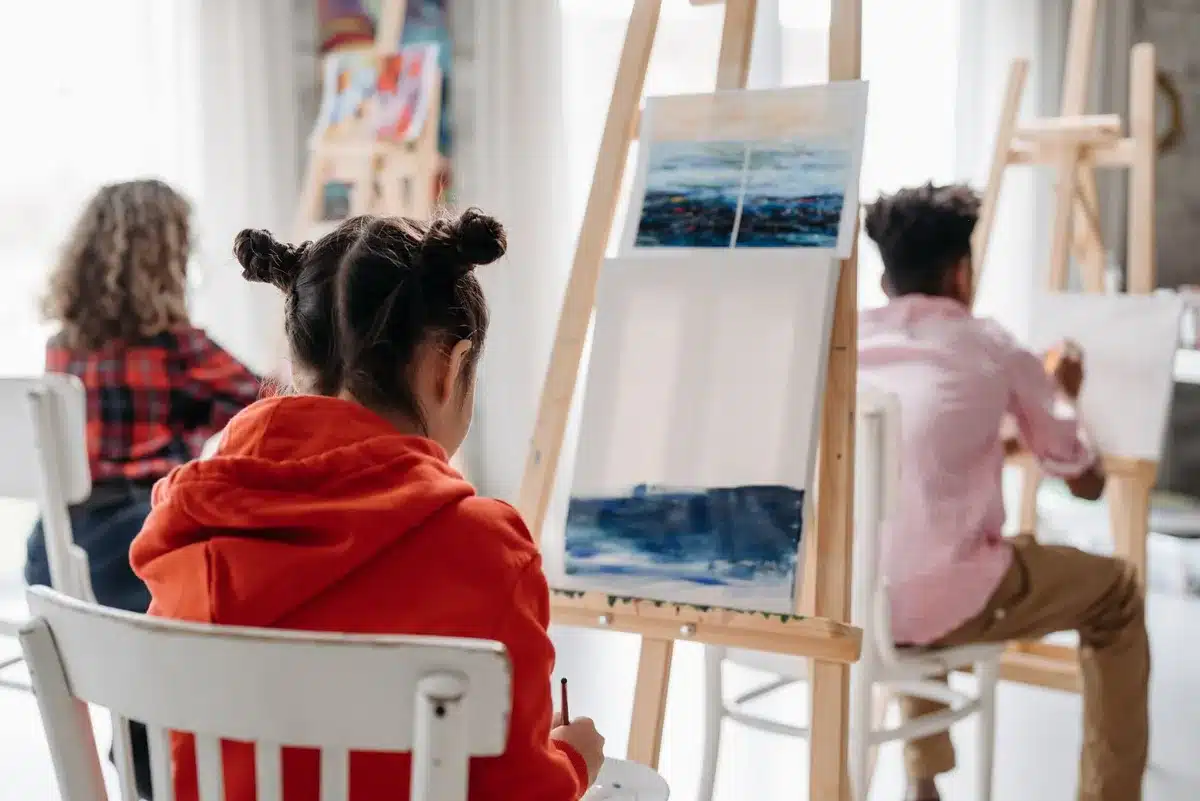 Group of people participating in a creative workshop using recycled materials in an educational setting