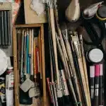 Assorted donated art materials including paints, brushes, and fabrics sorted at a creative reuse center