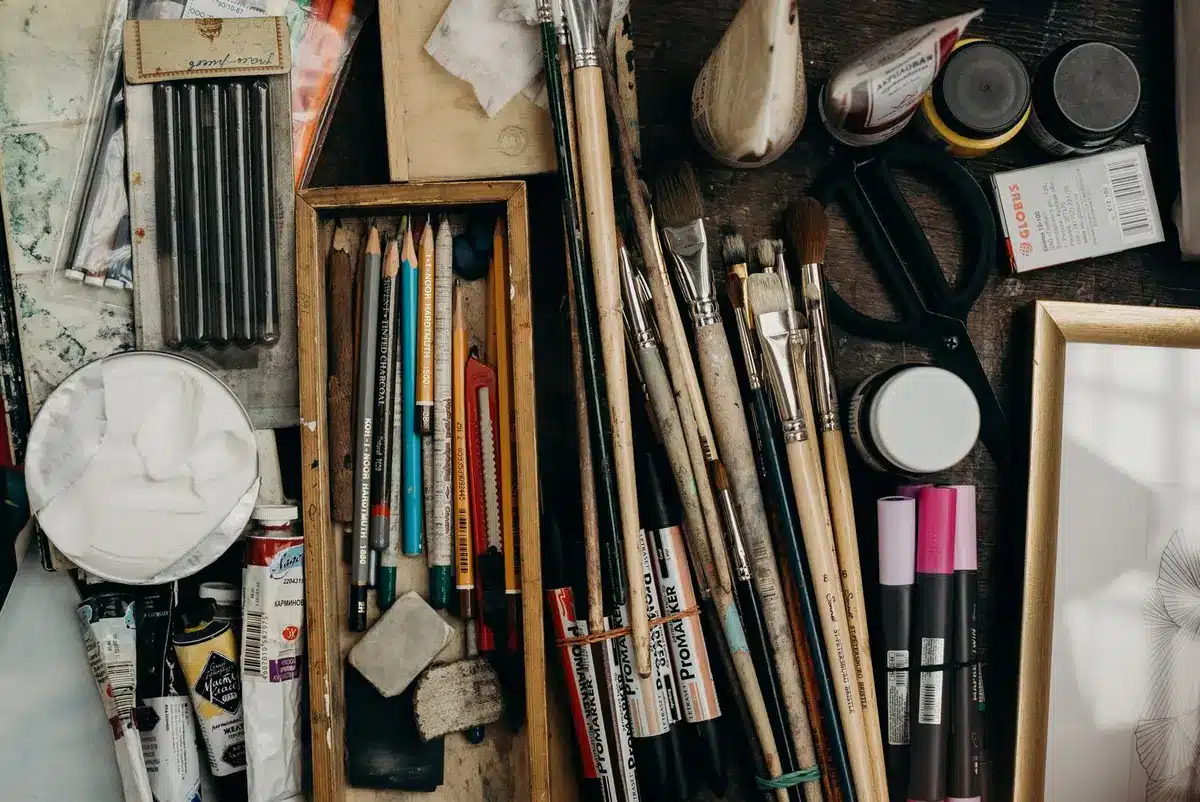 Assorted donated art materials including paints, brushes, and fabrics sorted at a creative reuse center