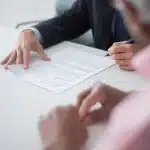 Regulatory documents and charts on a desk under office lighting, symbolizing environmental policy review