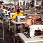 Industrial aircraft assembly line with workers inspecting fighter jet components