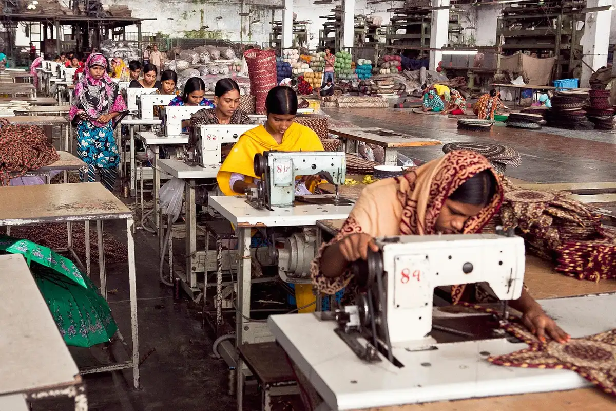 Industrial aircraft assembly line with workers inspecting fighter jet components