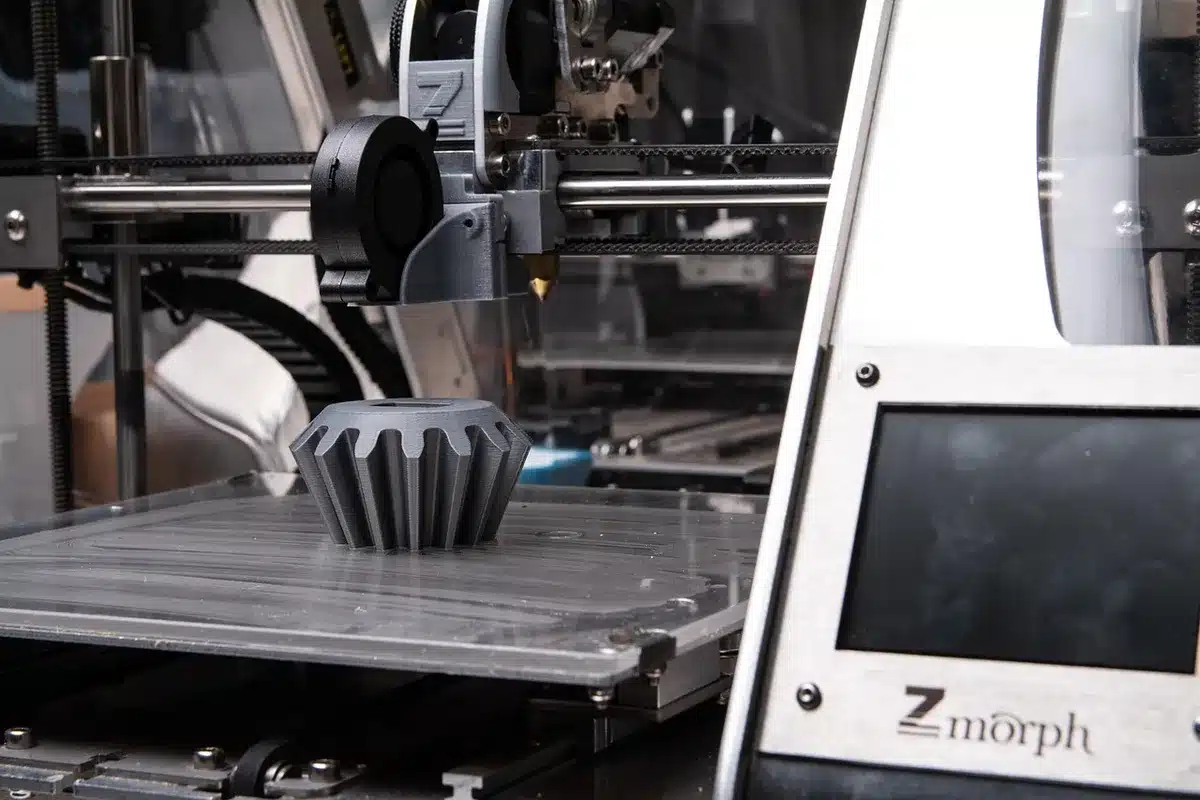3D printer in operation creating components through additive manufacturing layer by layer.