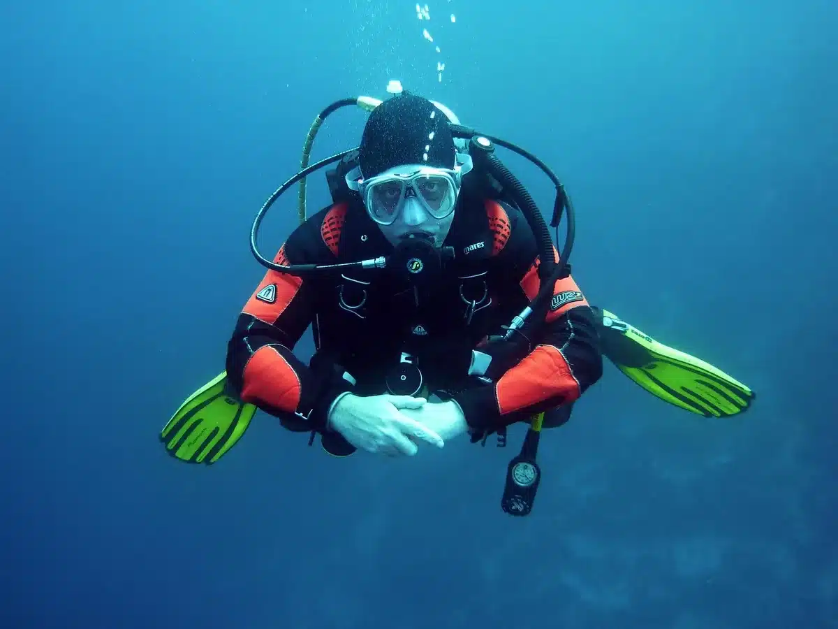 Diver working underwater to restore seagrass by planting shoots on seabed