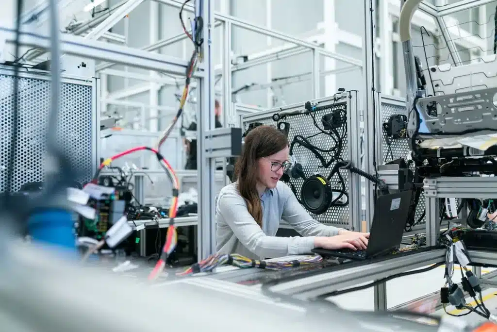 Factory floor with pallets of unbranded aerospace components and a silhouetted worker