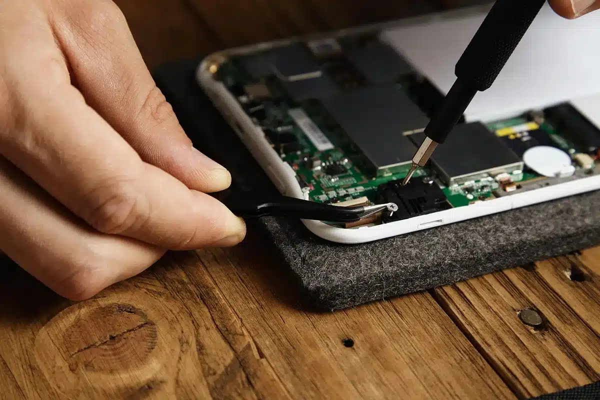 Workers' hands and unbranded circuit boards on an assembly line representing missile electronics production